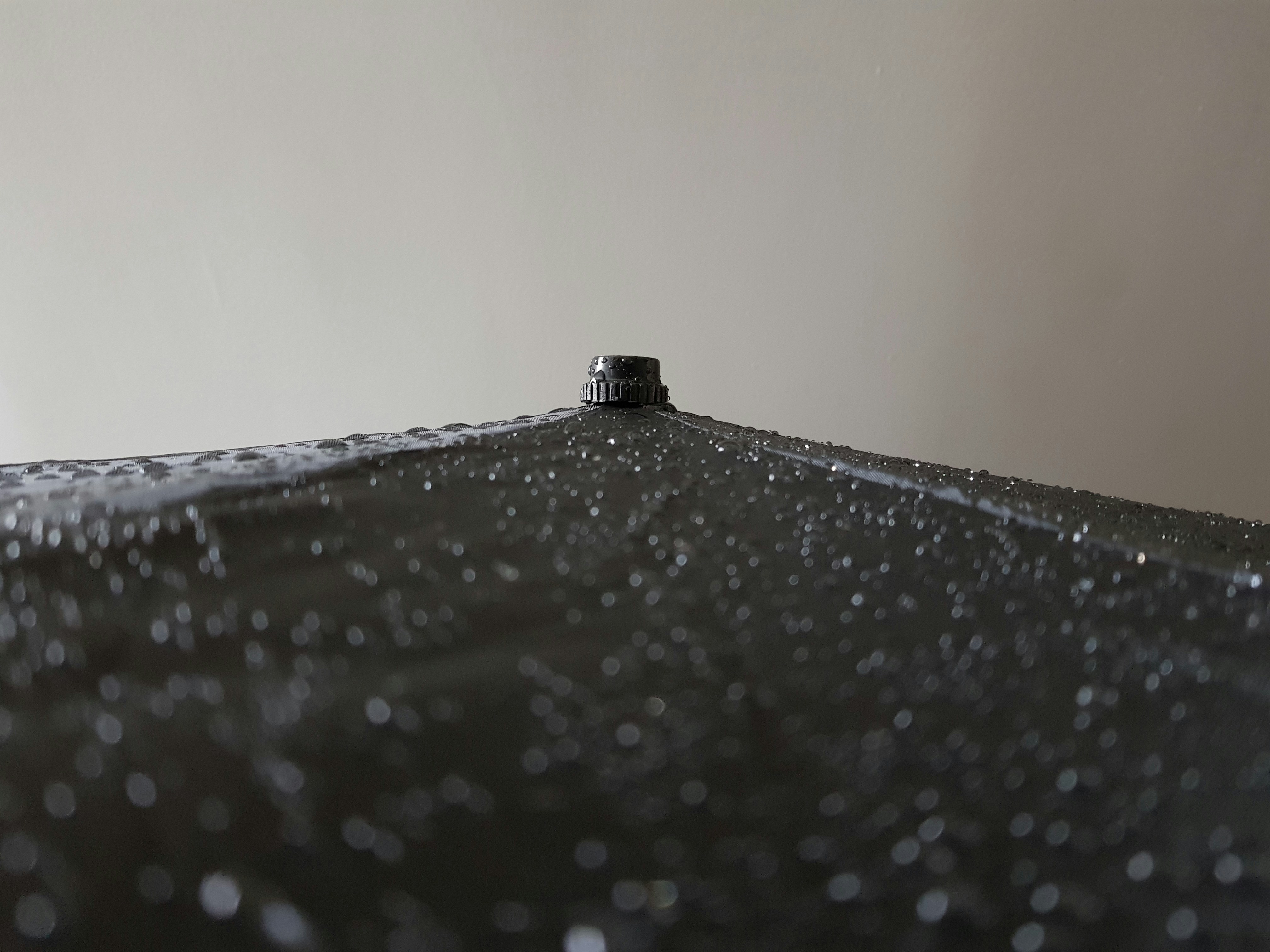 a black umbrella with water droplets on it