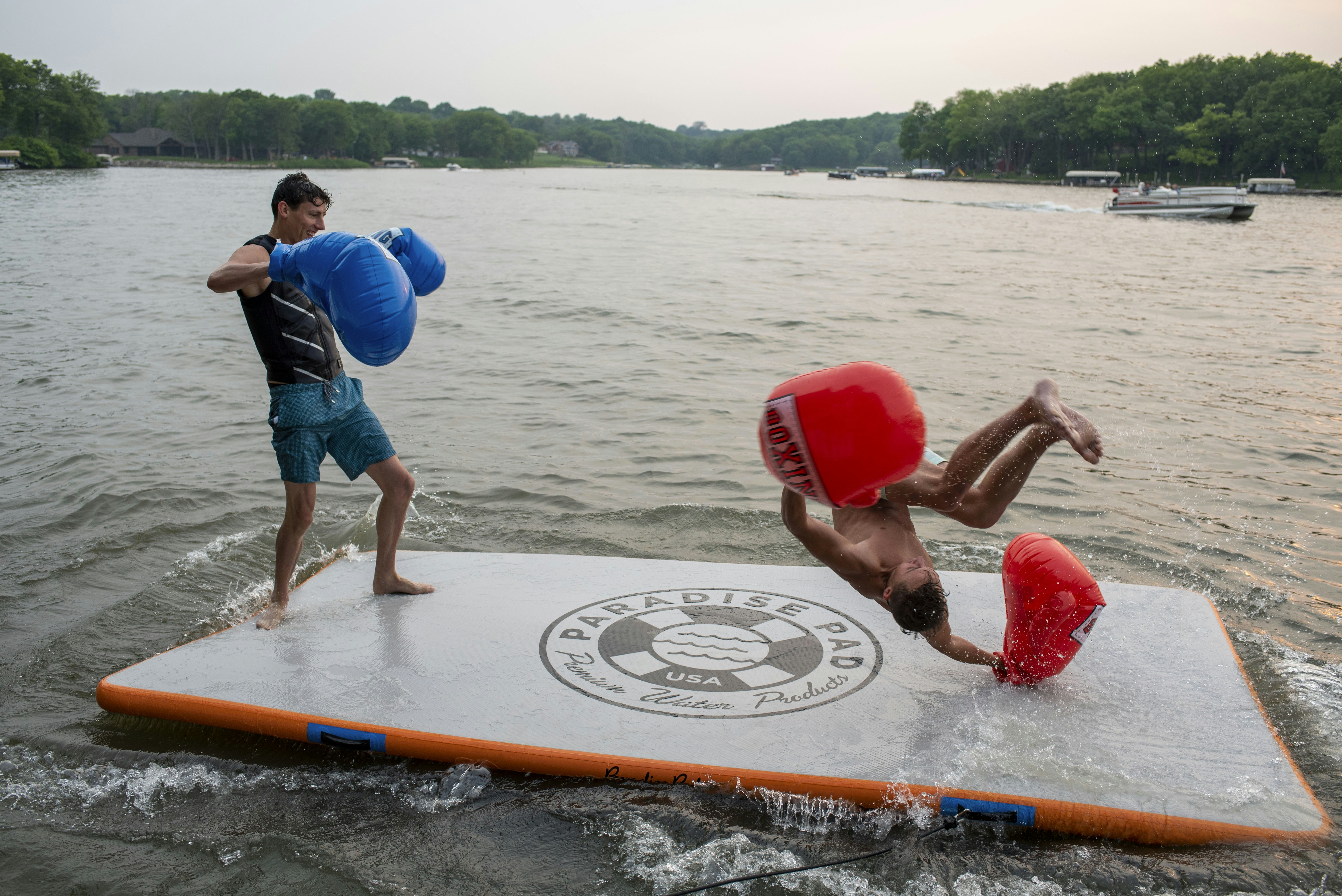 a man standing on top of a surfboard on top of a body of water
