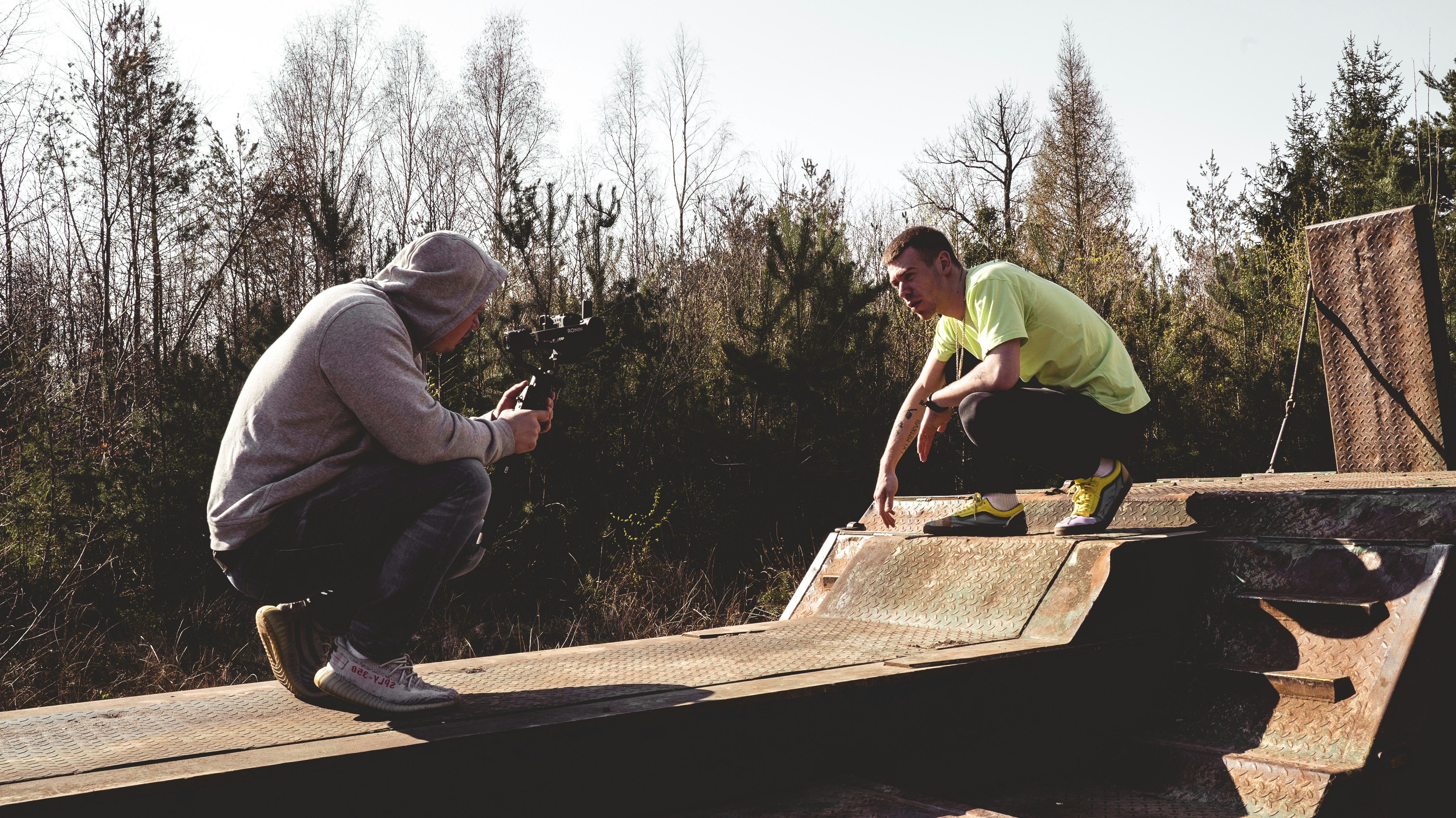 man in green shirt and black pants holding brown wooden board